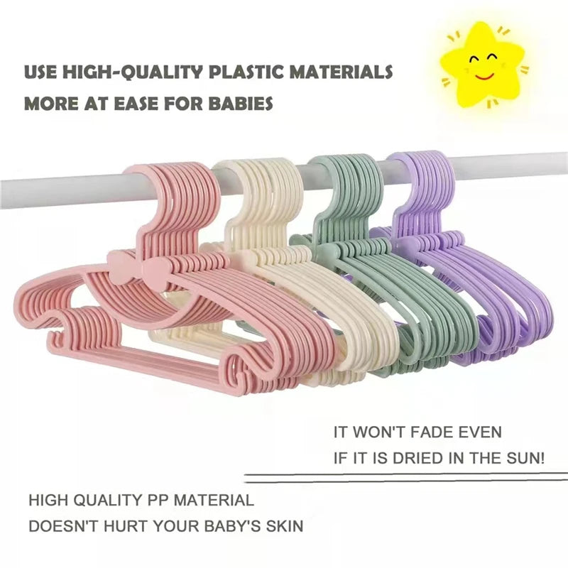 Set rosa und grün Kunststoffkleiderbügel zur Organisation von Babykleidung.