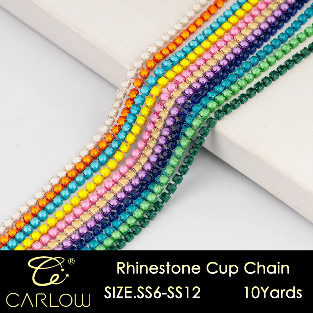 A close-up of a multi-color rhinestone cup chain featuring various shades of yellow, pink, purple, and green stones.