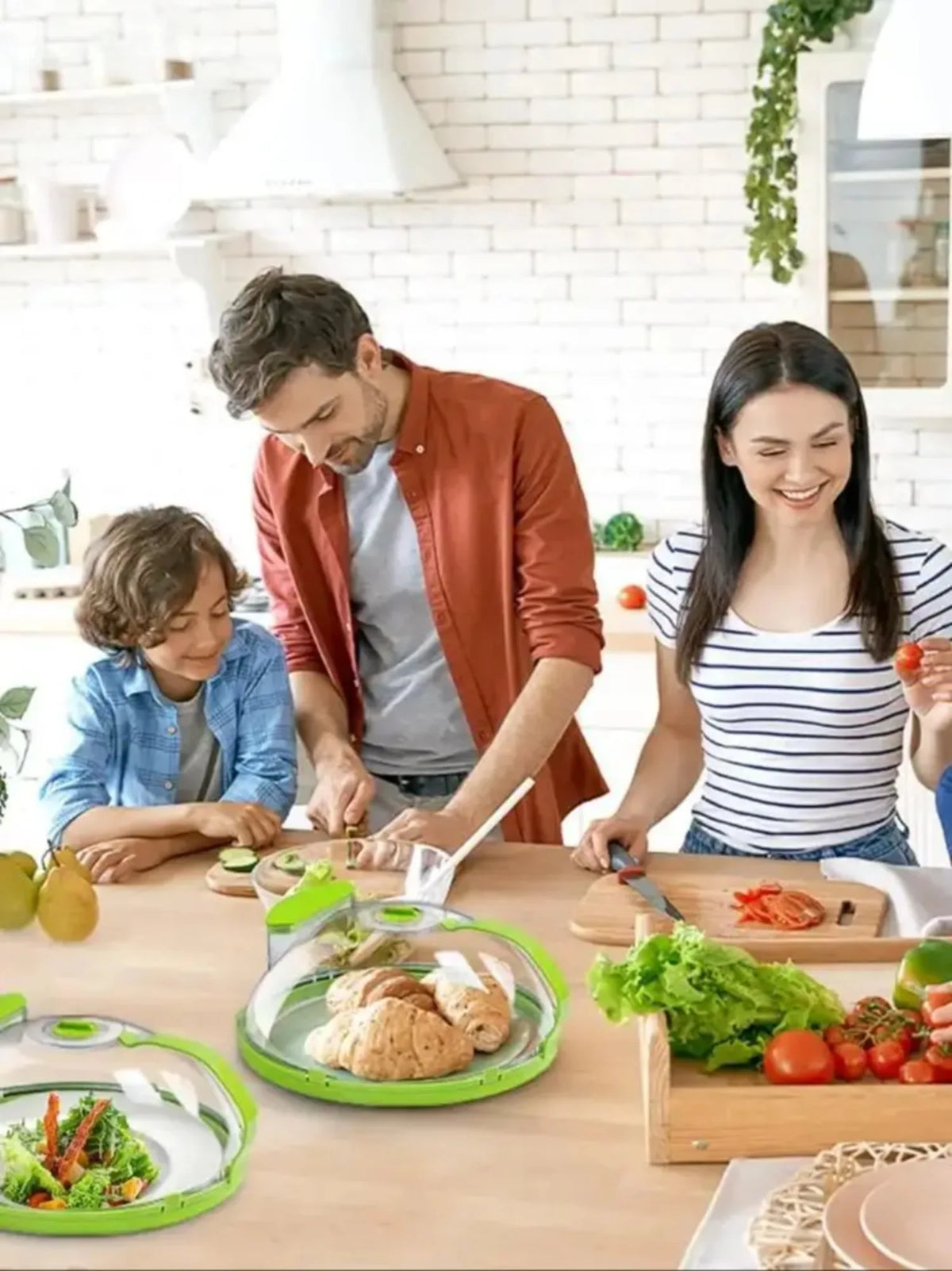 A woman and a man are preparing food on a wooden table, using a microwave splatter cover with a steamer and ergonomic handle.