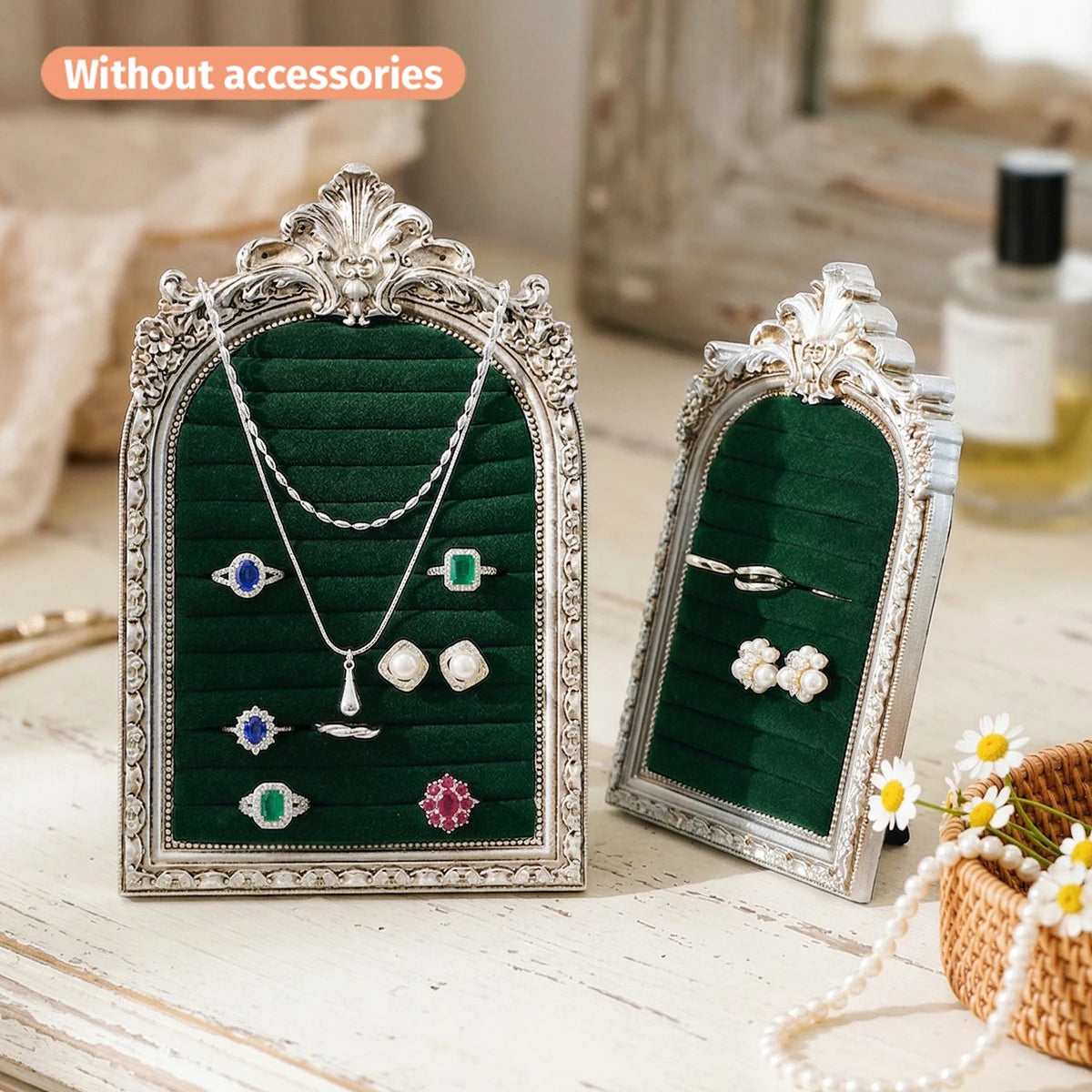 Silver arched resin jewelry display stand with a dark green velvet lining showcasing various necklaces and earrings.
