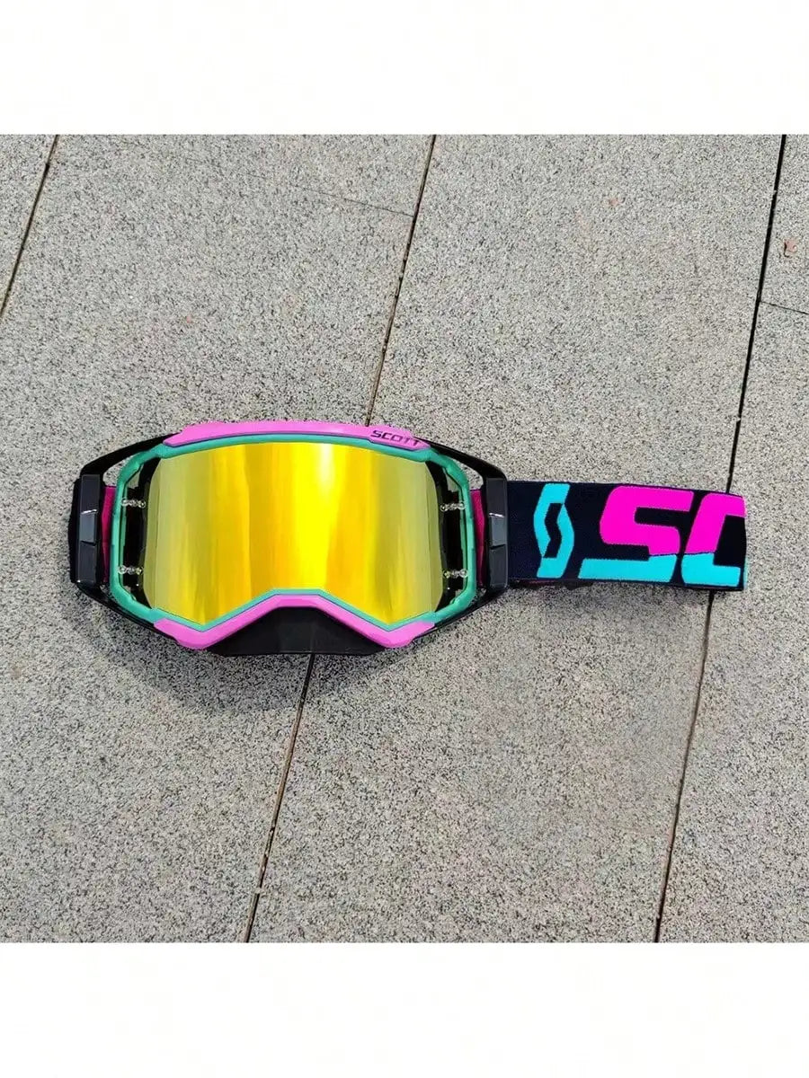A pair of bright yellow and black motocross goggles with pink accents resting on a gray paved surface.