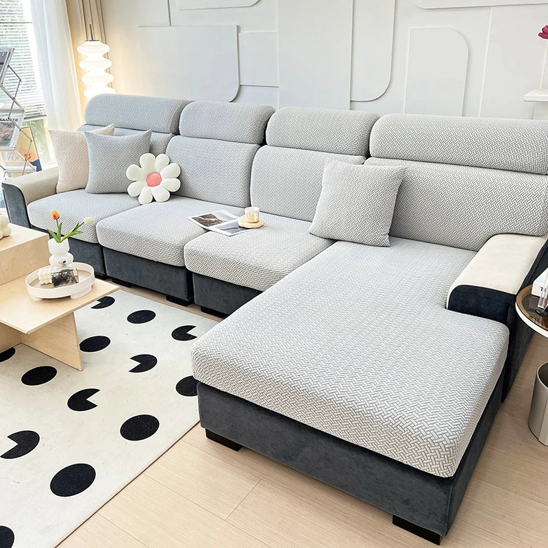 A modern gray sofa with a textured slipcover and dark accents sits in a bright living room.