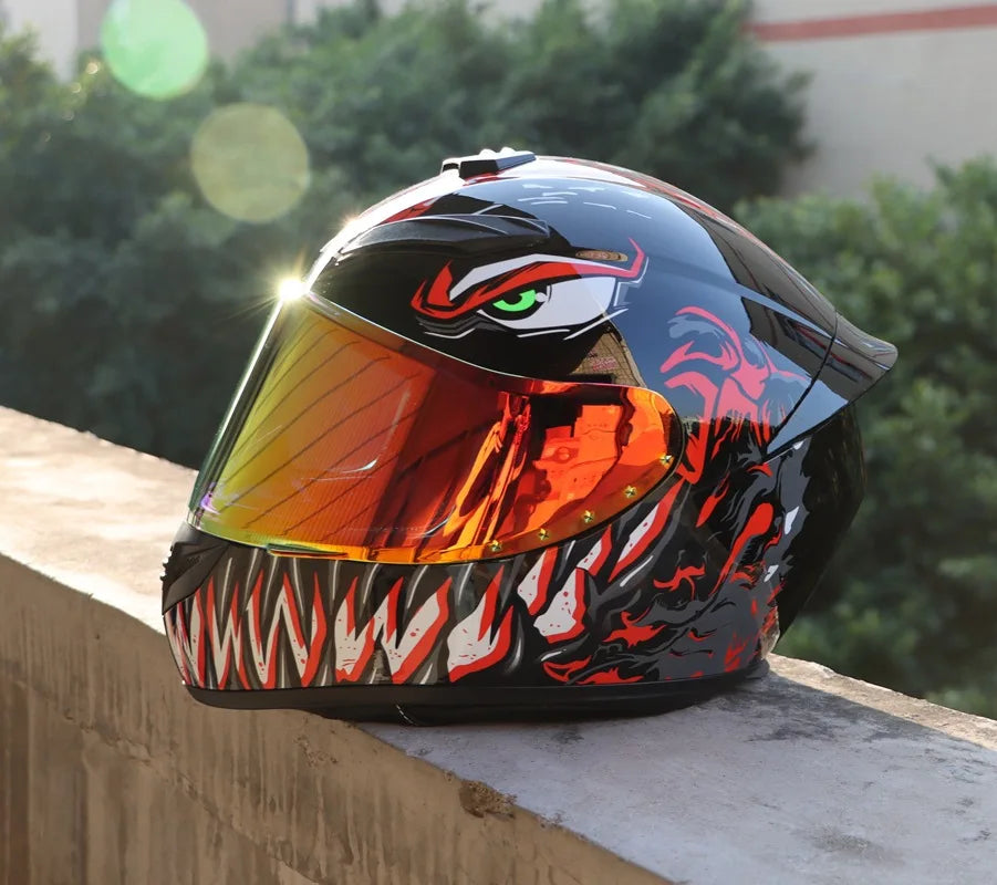 A glossy black and orange retro full-face motorcycle helmet resting on a concrete ledge.