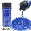 A glass bottle of blue holographic nail glitter mix with a black shaker top pouring glitter onto a surface.