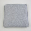 A square, gray felt mat used for wool crafting.