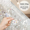 A hand is applying decorative stained glass window film to a surface, demonstrating its static cling feature.