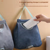 A blue mesh storage bag is hanging on a wall hook, demonstrating an unimpeded U-shaped opening for storing plastic bags.