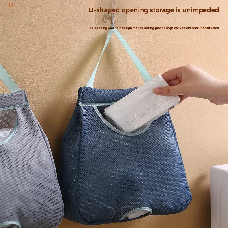 A blue mesh storage bag is hanging on a wall hook, demonstrating an unimpeded U-shaped opening for storing plastic bags.