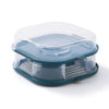 A clear plastic reusable non-toxic cockroach trap with a blue lid and mesh bottom.