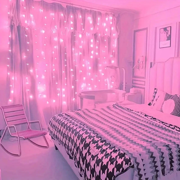 A bedroom decorated with pink LED curtain string lights illuminating sheer curtains and a bed.