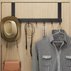 A wooden coat rack with six hooks is mounted on a wall, displaying a hat and a striped shirt.