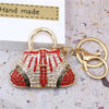 A red and gold crystal rhinestone handbag keychain with a gold split ring attached.