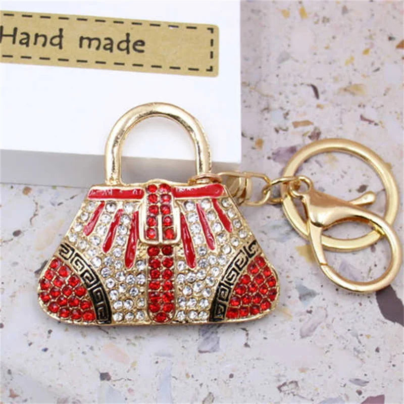 A red and gold crystal rhinestone handbag keychain with a gold split ring attached.