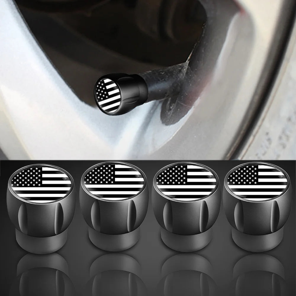 A set of four black tire valve caps featuring an American flag design, shown against a dark background.