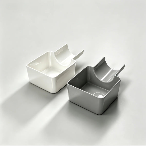 A pair of white and gray washing machine drain funnels with overflow guards and drip pans shown on a light surface.
