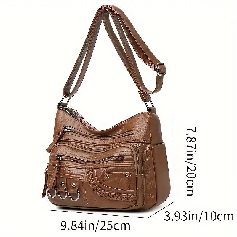 A brown vintage PU leather crossbody bag shown from the side with a strap and pocket details.