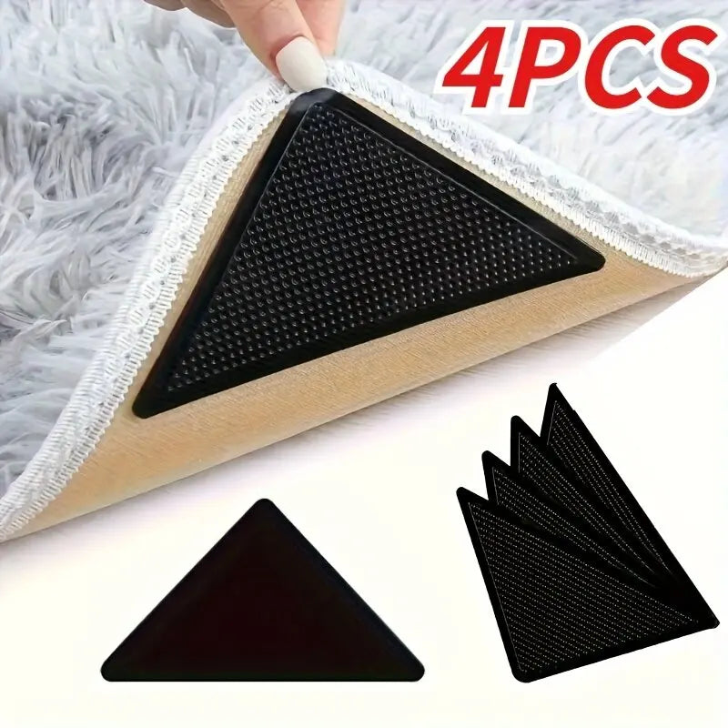 Four black non-slip rug pad grippers used to secure rugs on hardwood and tile floors