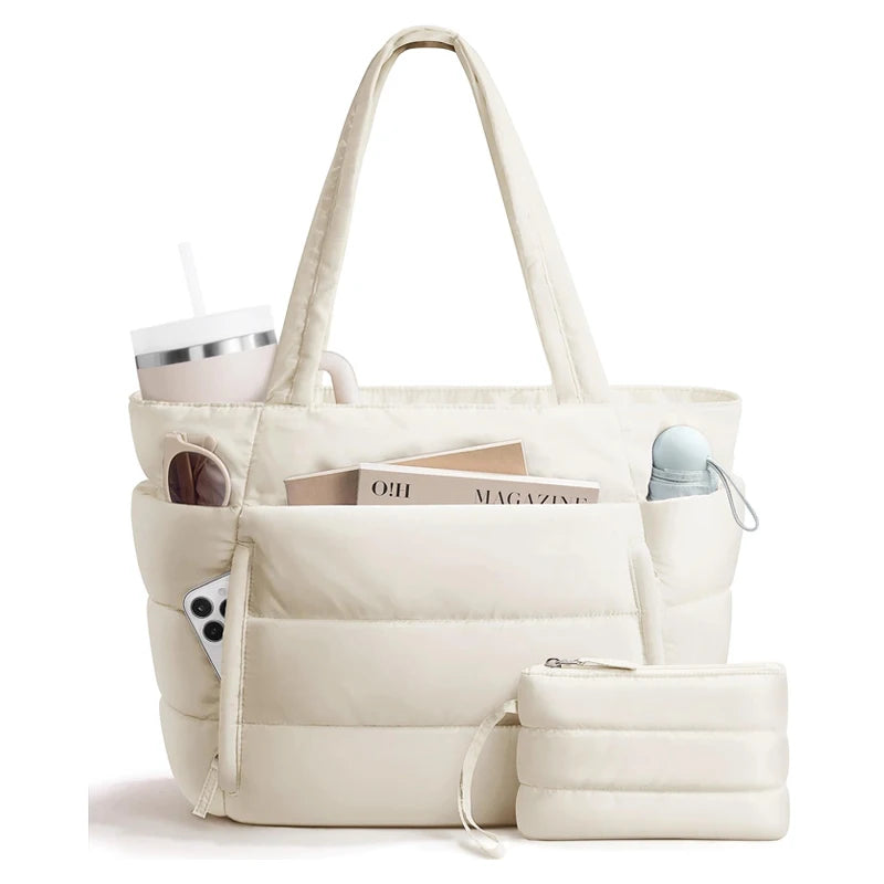 A cream-colored quilted puffy tote bag with a handle and an interior laptop sleeve.