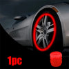A close-up of a car wheel with a red glowing tire valve cap installed, showing one piece.