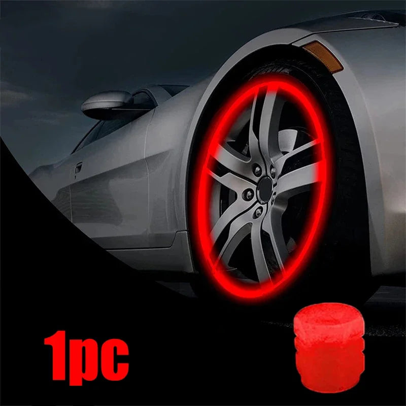 A close-up of a car wheel with a red glowing tire valve cap installed, showing one piece.