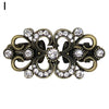 Vintage gold-toned swirl sweater clip featuring clear rhinestones and decorative metalwork