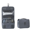 A gray travel makeup bag with a hanging hook, showing an open compartment and a separate zippered pouch.