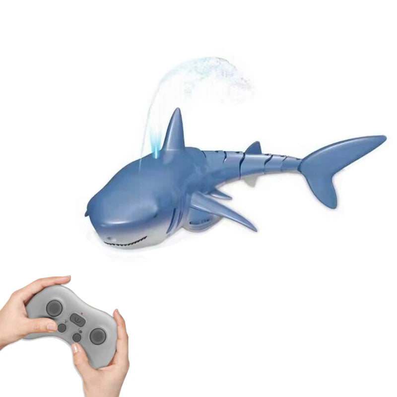 A blue shark toy is spraying water, being held by a person's hand.