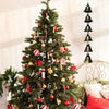 A decorated Christmas tree with ornaments and ribbons, used as a backdrop for vintage iron wind chimes.