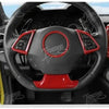 Close-up view of a black steering wheel interior with red accents and a red trim piece.