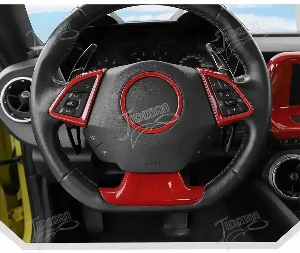 Close-up view of a black steering wheel interior with red accents and a red trim piece.