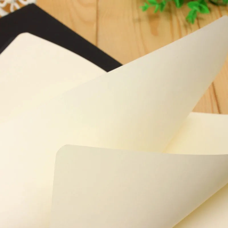 A close-up of a white A6 Kraft paper blank notebook for sketching and journaling resting on a wooden surface.