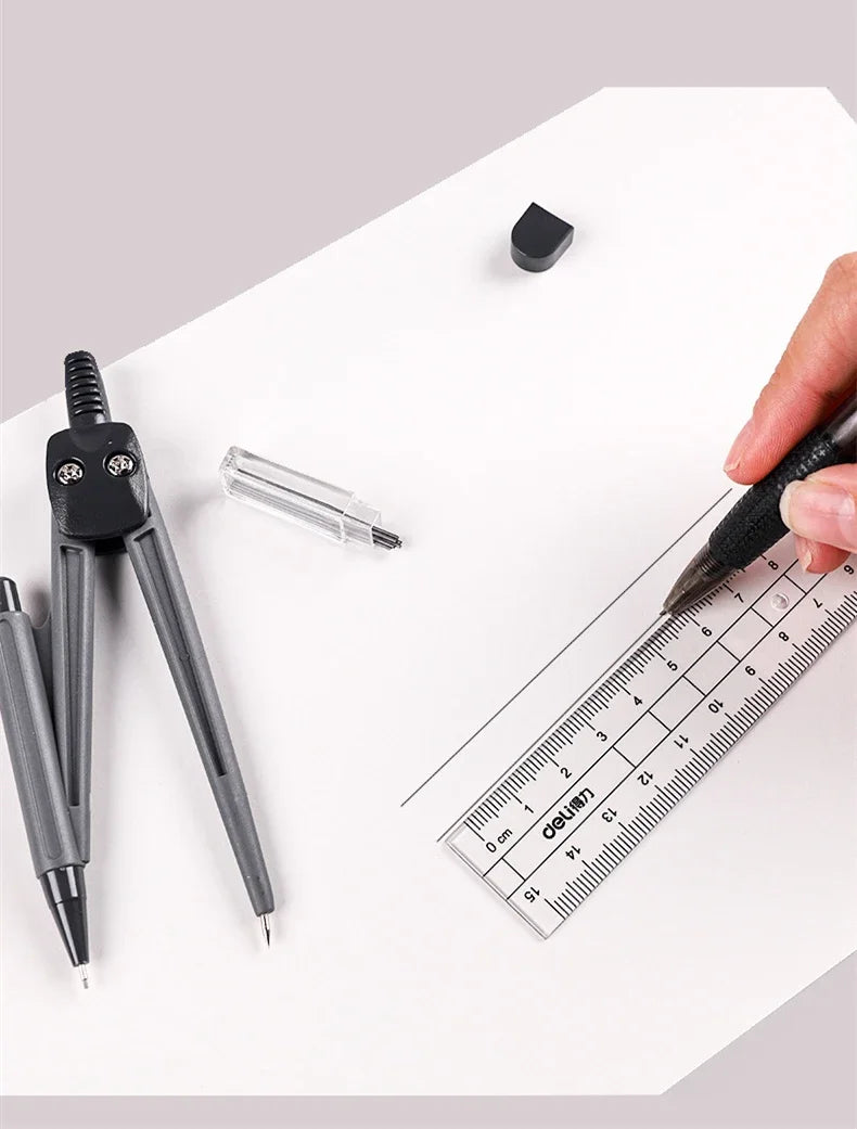 A hand holds a black pen over a white sheet of paper with a drafting set including a compass, ruler, and other tools.