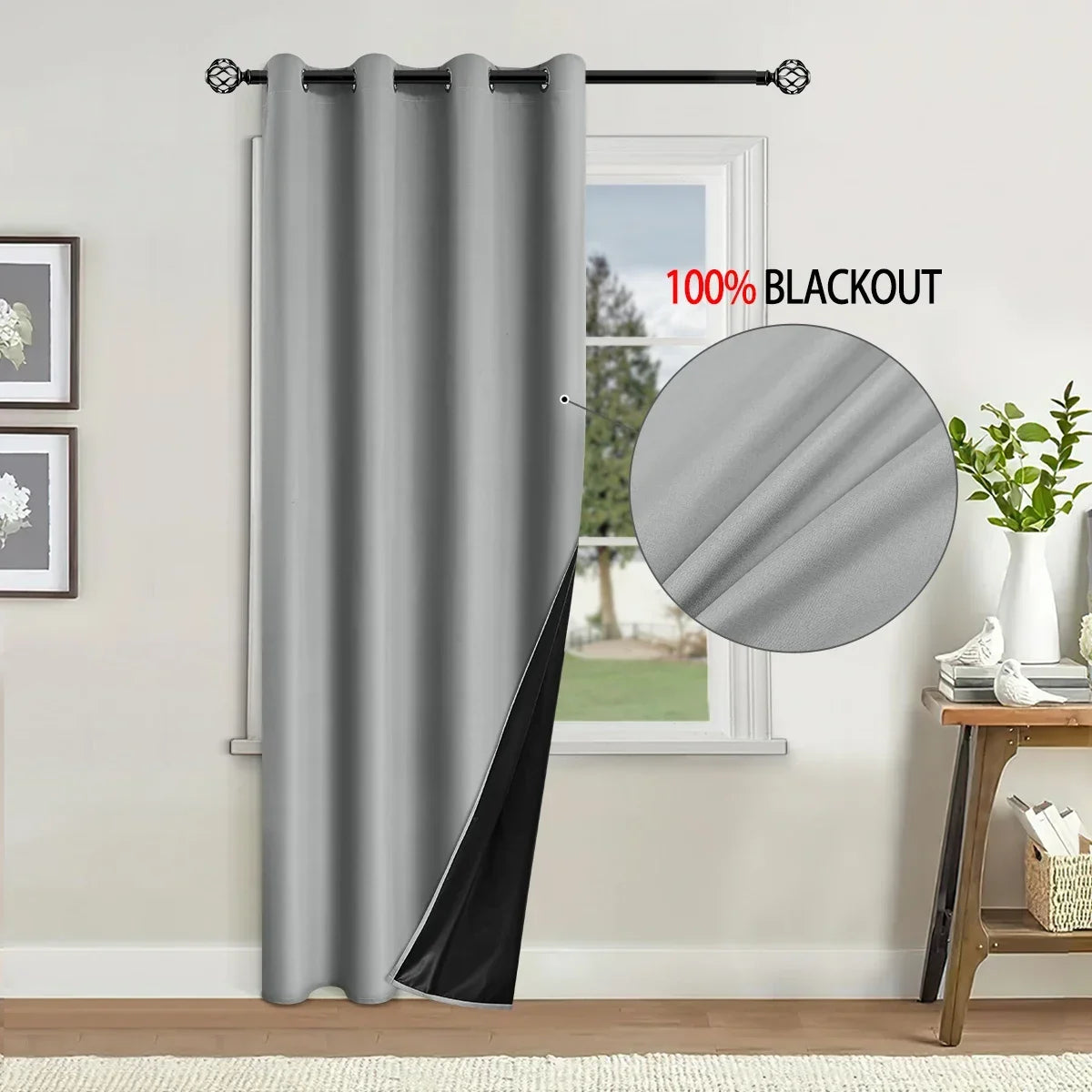 A gray blackout curtain hanging on a rod next to a window.