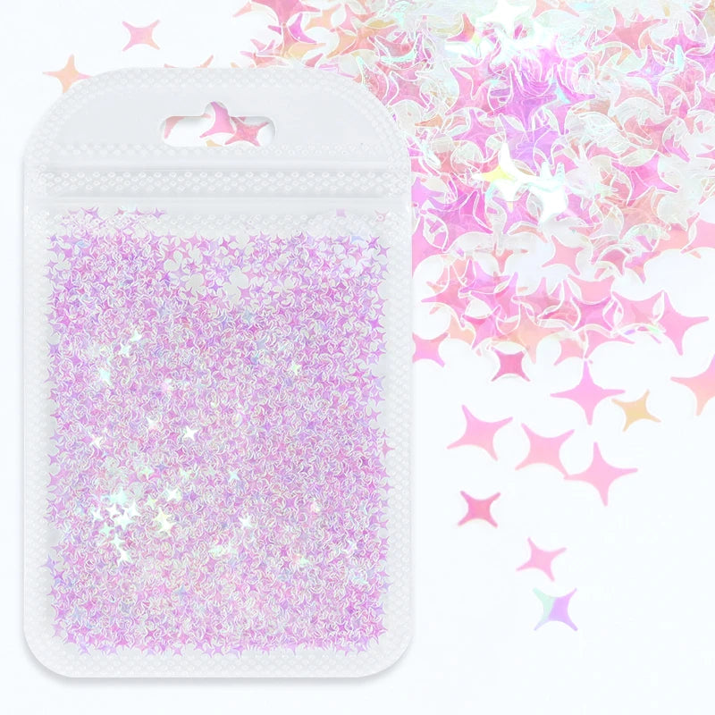 A white plastic pouch filled with iridescent purple and pink holographic star sequins for resin crafts.