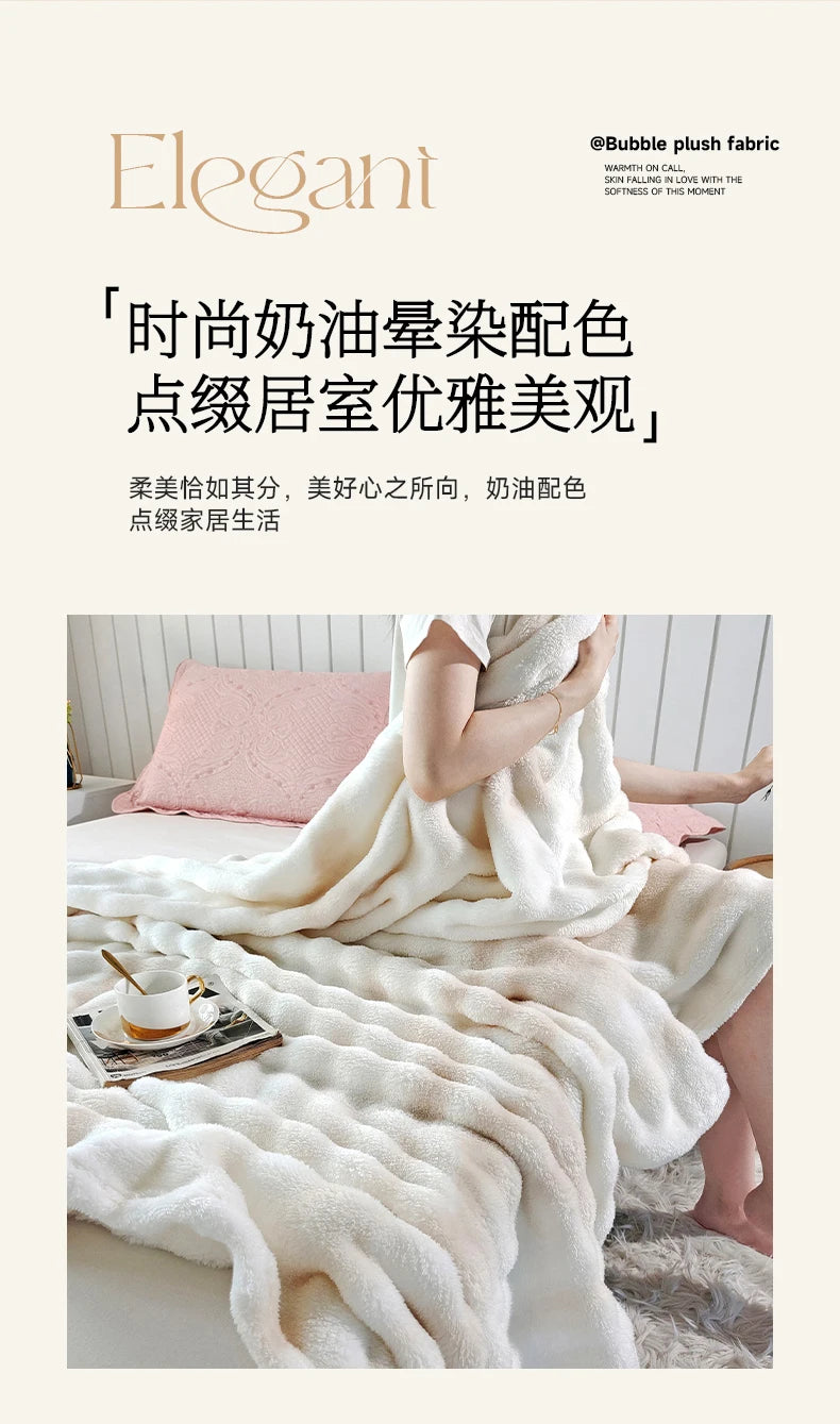 A fluffy white gradient fleece throw blanket draped over a person on a bed.