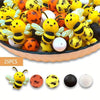 A bowl filled with colorful 3D bee silicone beads in yellow, orange, and white for jewelry making and DIY crafts