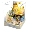 A miniature dollhouse kit featuring a wooden garden scene with flowers and illuminated elements.