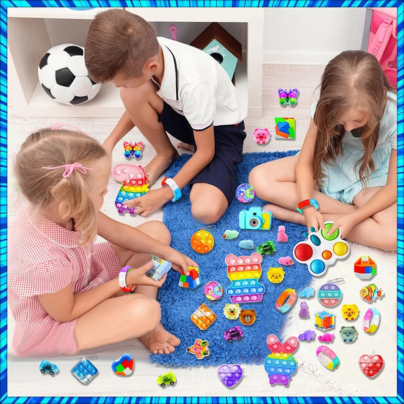 A collection of colorful kids party favors including snap bracelets, fidget toys, and small plastic items arranged on a white