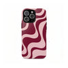 A phone case for an iPhone featuring a dual-layer design with pink and maroon wavy stripes.