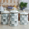 Three white and gray checkerboard porcelain storage jars with gold lids