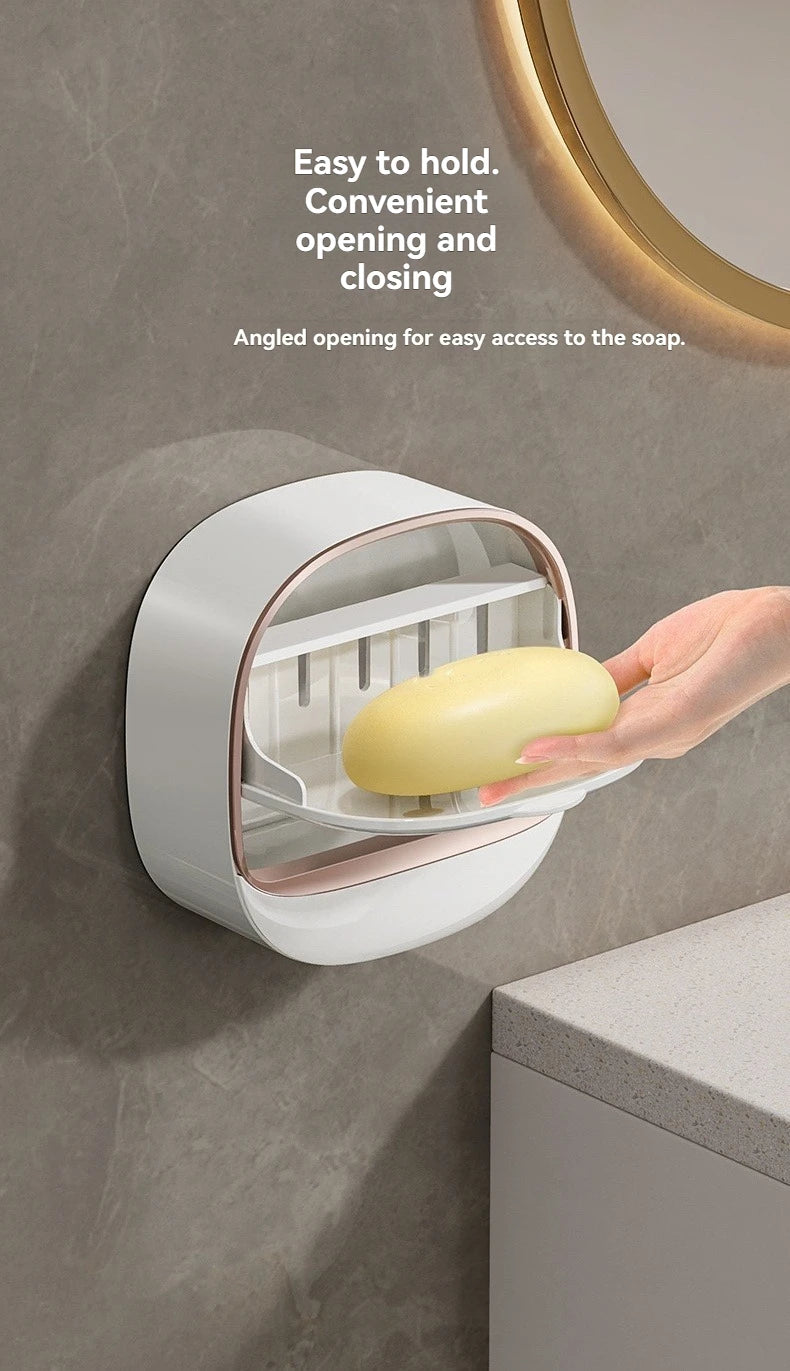 A hand is holding a yellow soap bar inside a white, angled hanging holder designed for easy access.