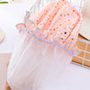 A reusable elastic shower cap for women in pink and white with gold polka dots, shown on a white surface.