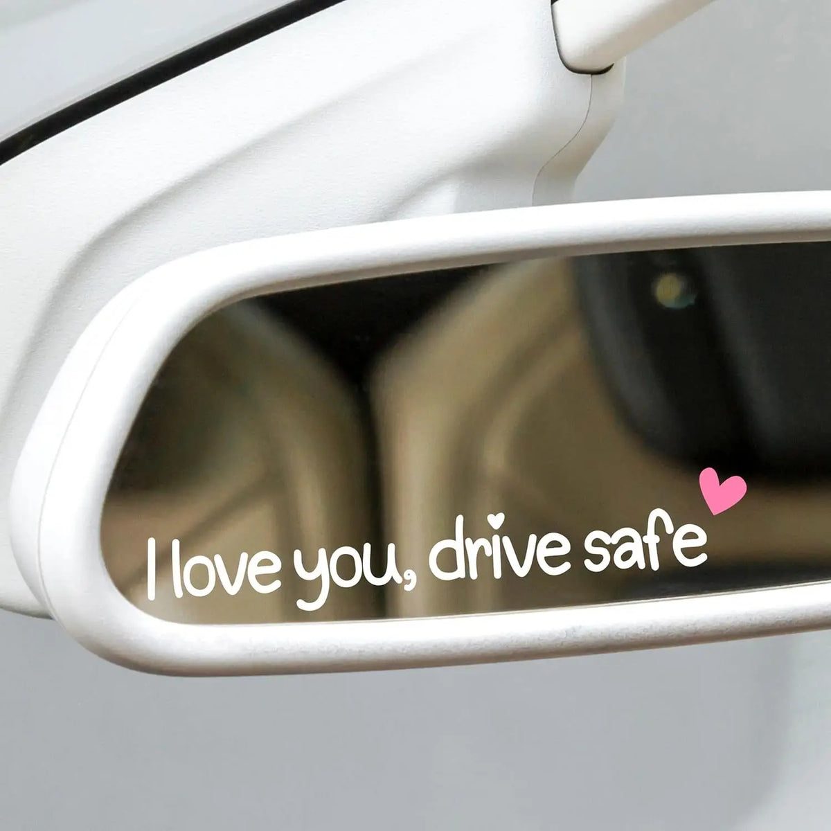 A close-up view of a car decal sticker set featuring the text I love you drive safe on a window.