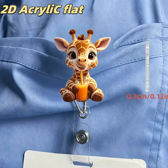 A 2D acrylic flat figurine of a baby giraffe holding an orange straw, displayed against a blue fabric.