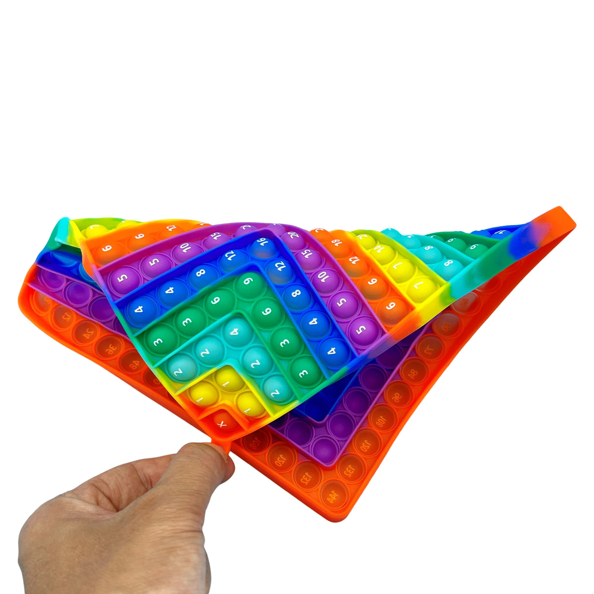 A hand holds a colorful multiplication practice math game board with various colored tiles.