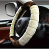 A steering wheel covered in a plush, brown and cream cartoon animal-themed fabric.