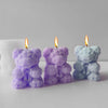 Three scented candles shaped like bears made from purple, lavender, and blue silicone molds.
