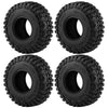 A set of four black mud terrain rubber tires for RC crawlers, showing the tread pattern and mounting holes.