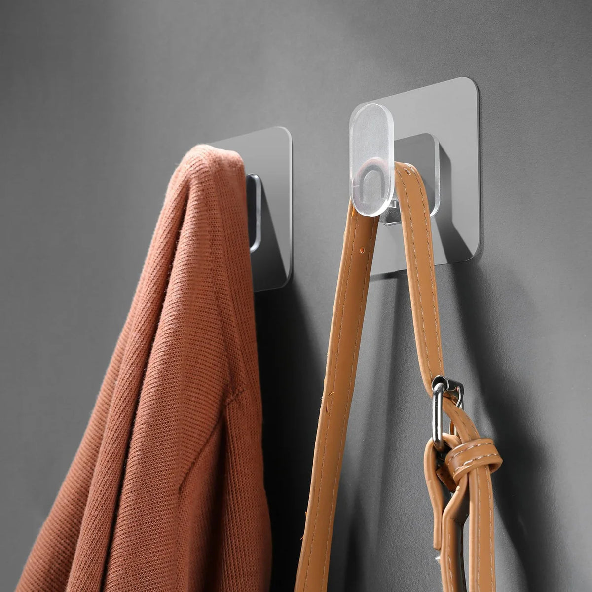 A close-up of a tan coat hanging on a gray wall, featuring an extra-large strong adhesive hook for organization.