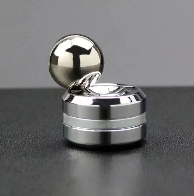 A silver metal desk spinner featuring a smooth ball on a rotating base.